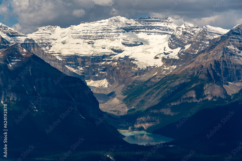 Iconic Lake Louise seen from a distance near the gondola with stunning mountain views surrounding the turquoise nature, national park area. 