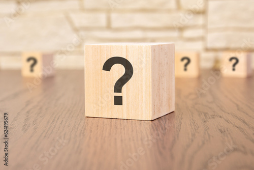 wooden blocks with question sign on wooden table, close up. space for text