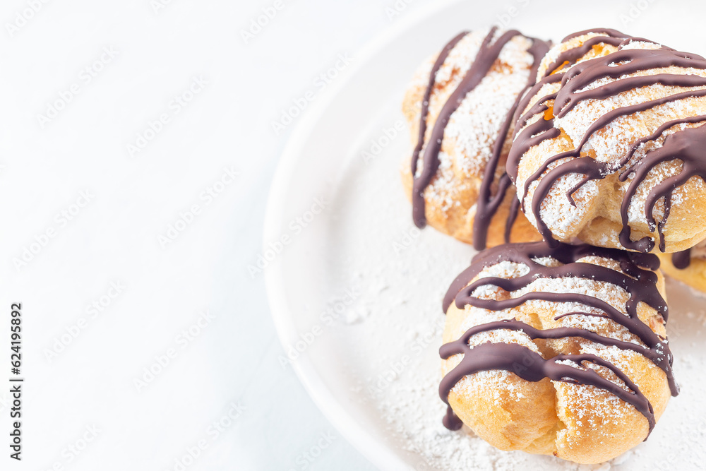 Profiteroles with whipped cream and chocolate filling, horizontal, copy space Profiteroles with whipped cream and chocolate filling, horizontal, copy space