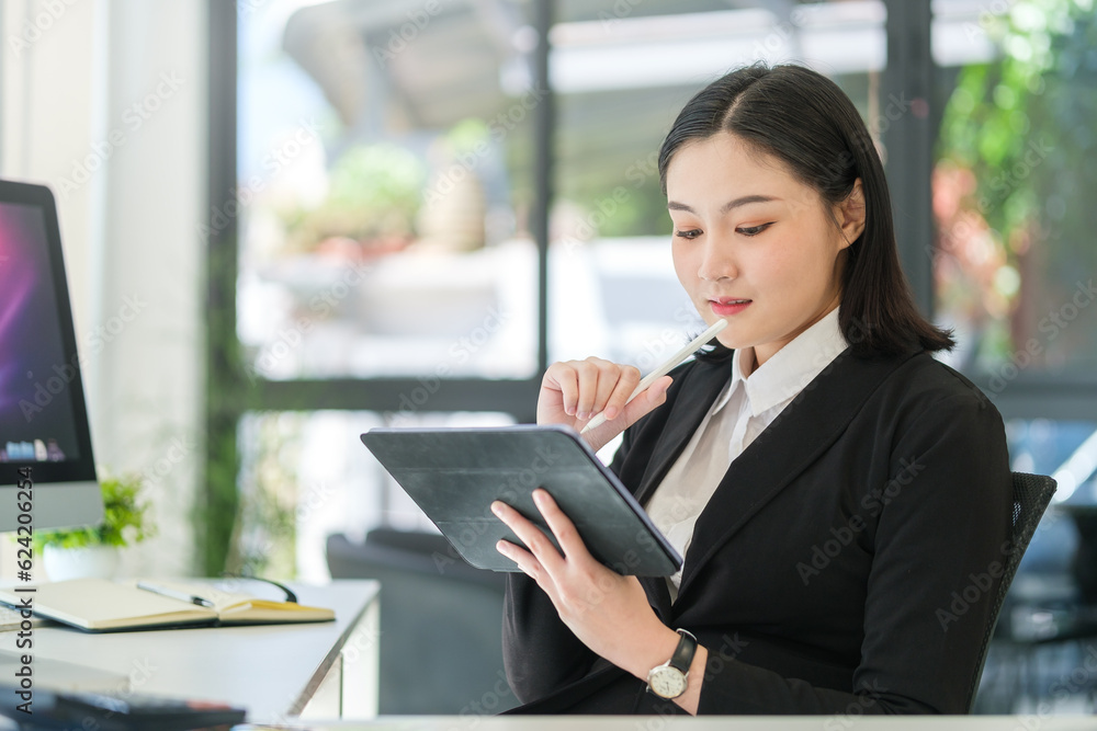 Smiling beautiful businesswoman holding stylus pen and writing information on digital tablet. Smiling beautiful businesswoman holding stylus pen and writing information on digital tablet.