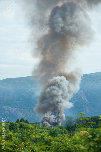 Wildfire in green forest in mountainous area