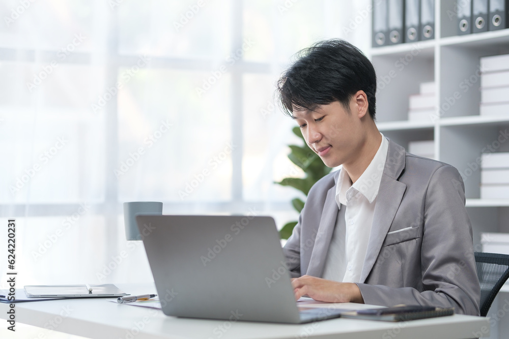 Smiling young businessman checking schedule, planning workday at his office desk. Smiling young businessman checking schedule, planning workday at his office desk.