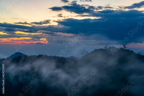 Clouds are moving over the mountains with sunset in the evening (Chiang rai, Thailand) © Puwaphat