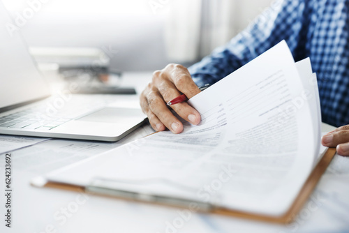Close-up view, asian businessman reviewing before sign document reports at office workplace. legal expert, professional lawyer reading and checking financial documents or insurance contract