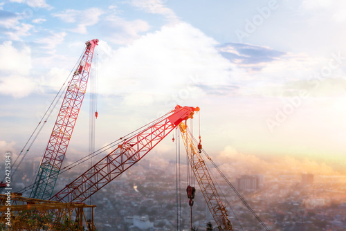 the tower crane and mobile crane and collar crane and construction site in the afternoon time with sunset. there are slings, and hooks, to try to build the city. photo