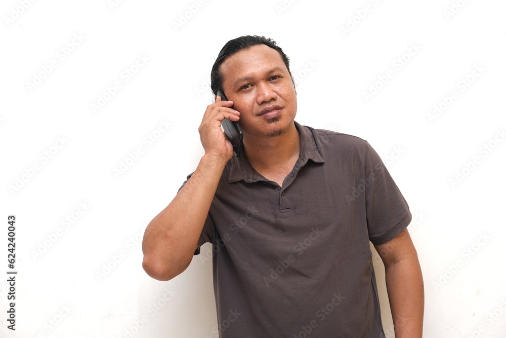 confident asian man is communicating using mobile phone confident asian man is communicating using mobile phone