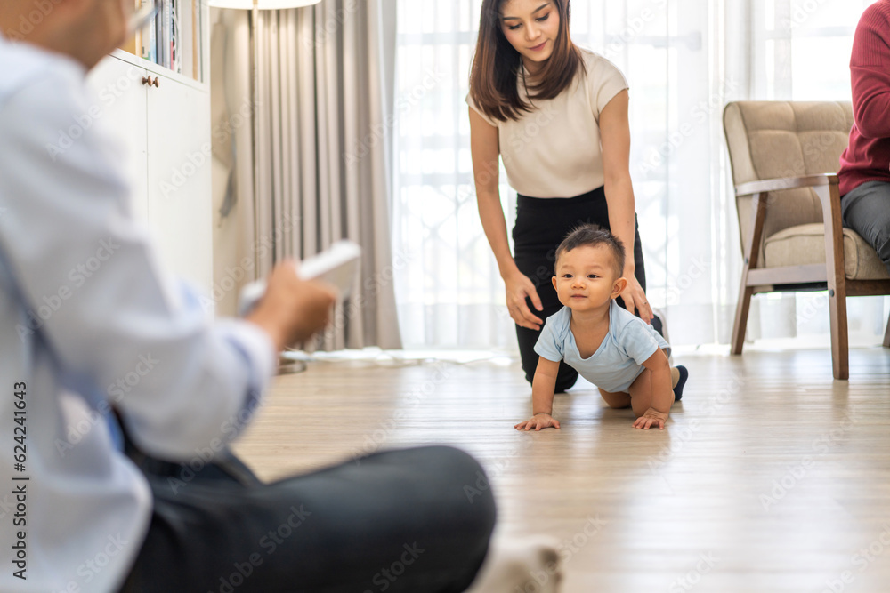 Obraz premium Portrait of enjoy happy love family asian mother playing and teaching help adorable little asian baby learning to crawling.Mom help first step with cute son beginnings development at home.Love, family