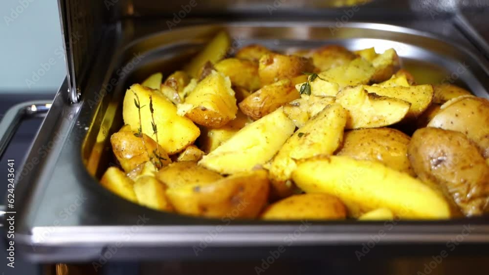 delicious baked potatoes in a buffet in a metal bowl at an event delicious baked potatoes in a buffet in a metal bowl at an event