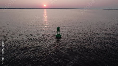 Aerial orbit video of a green navigation bouy during sunset in Narragansett Bay, Warwick, RI.  photo