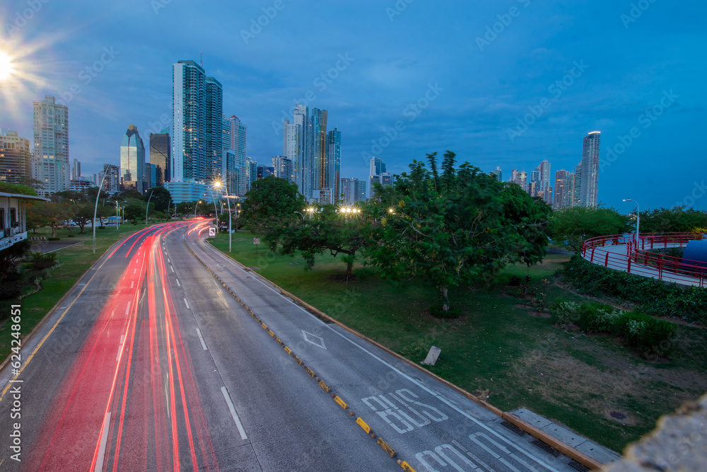 Night or evening cityscape of Panama city with skyscrapers and beachfront. Light trails visible due to traffic flowing on the motorway below. Romantic modern photo of Panama city