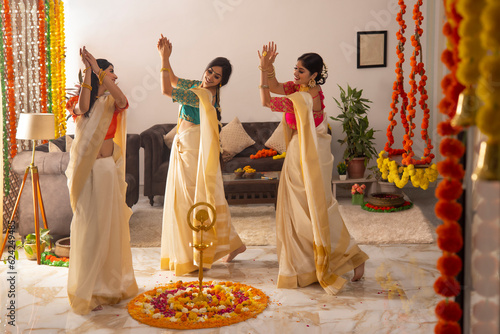 Women in white saree dancing together on the occasion of Onam
