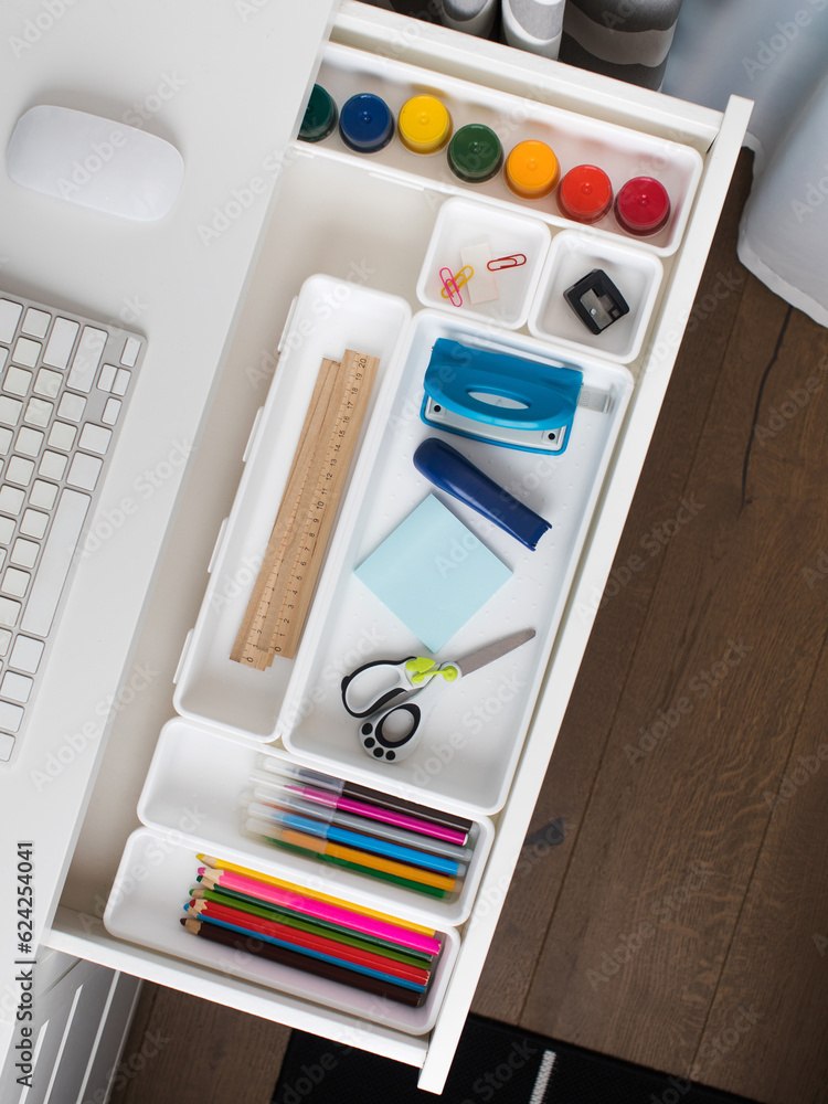 Office supplies are laid out in a white plastic container in the shelf of the desk. Back to school. Office supplies are laid out in a white plastic container in the shelf of the desk. Back to school.