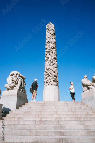 Couple taking a photo of the column of life at Vigeland Sculpture Park in Oslo, Norway
