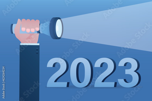 Economic prospects in 2023. Visionary illuminates future. Businessman hand uses flashlight for lighting way and number 2023 year. Business opportunities and targets or goals. photo