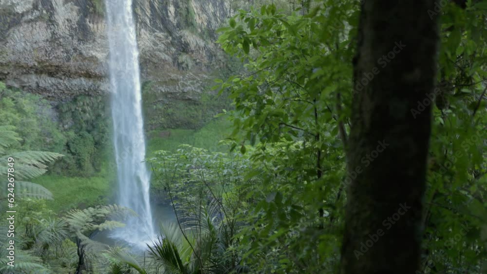A shot of a waterfall called bridal falls in Raglan New Zealand. The waterfall is surrounded by nature, and a rock face. A shot of a waterfall called bridal falls in Raglan New Zealand. The waterfall is surrounded by nature, and a rock face.