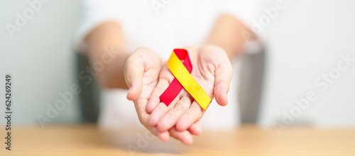 Fotografie woman holding Red and Yellow ribbon