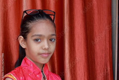 An Indian little pretty girl fiddling with her eye glasses in various poses.