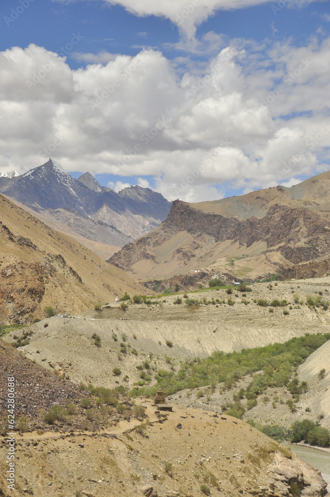 Scenic view of flowing river in between  rocky mountains with clouds in the sky on the way of Padum, Zanskar, Ladakh, INDIA 