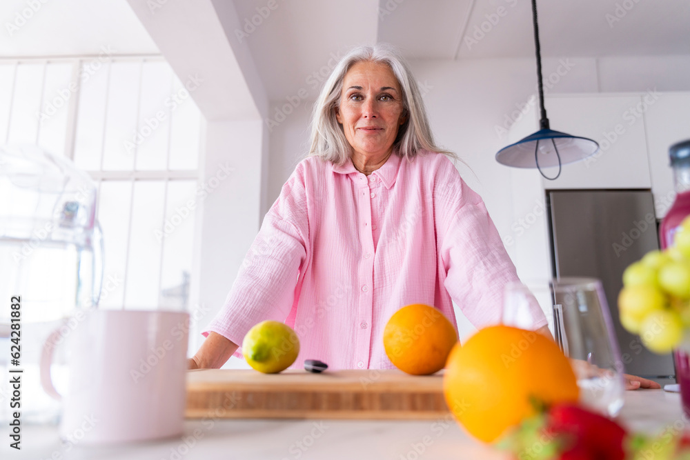 © Westend61 - Smiling mature woman leaning on kitchen counter at home © Westend61 - Smiling mature woman leaning on kitchen counter at home