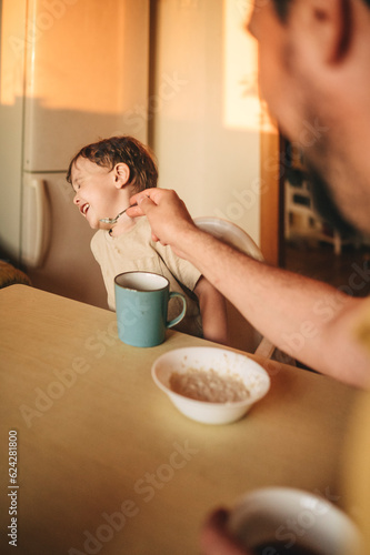 Boy refusing to eat porridge at dining table photo