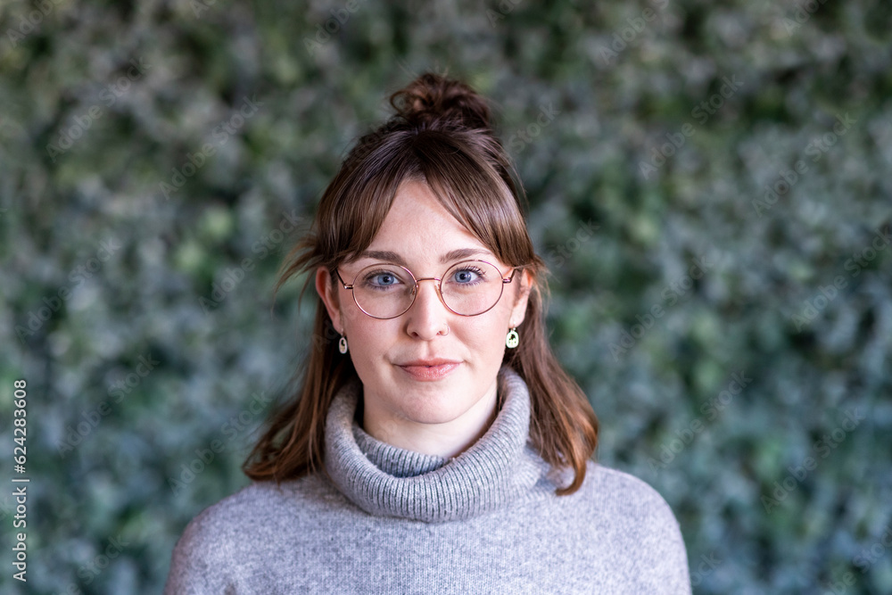Smiling businesswoman wearing eyeglasses in front of wall Smiling businesswoman wearing eyeglasses in front of wall