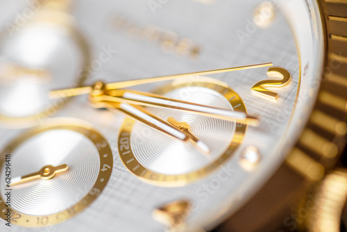 Wrist clock. Close up of a golden clock face with ticking arms.