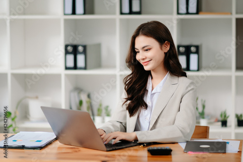 Business woman using tablet and laptop for doing math finance on an office desk, tax, report, accounting, statistics, and analytical research concept in office