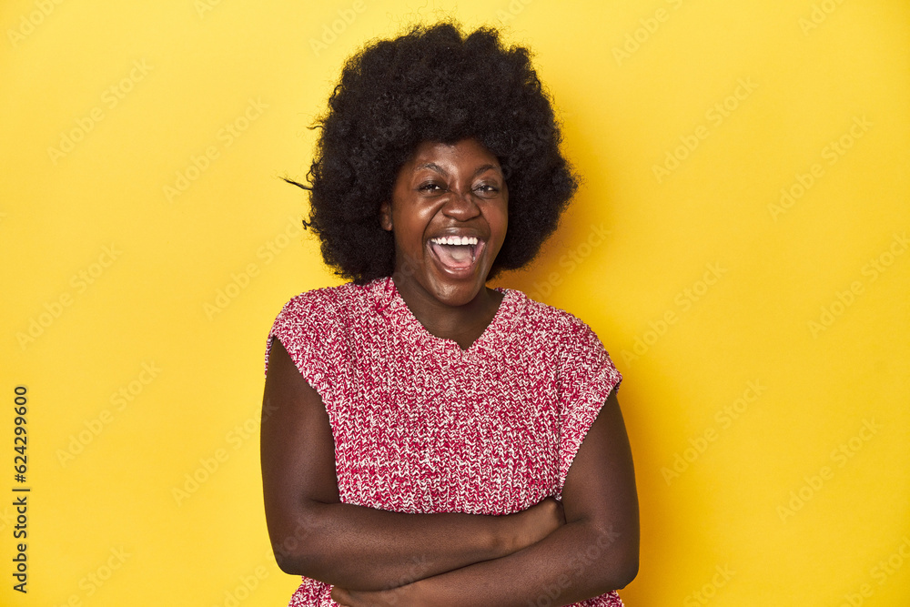 African-American woman with afro, studio yellow background laughing and having fun. African-American woman with afro, studio yellow background laughing and having fun.