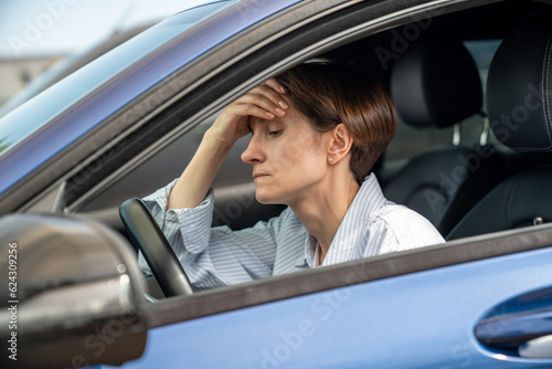 Burnout. Tired unhappy woman sitting inside car. Exhausted female of middle age running away from abusing husband make decision where to go. Upset lady thinking of marriage problems before return home