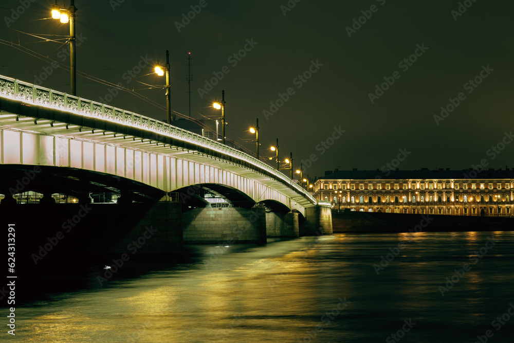 Naklejka premium Cityscape at night. View of the river and drawbridge.