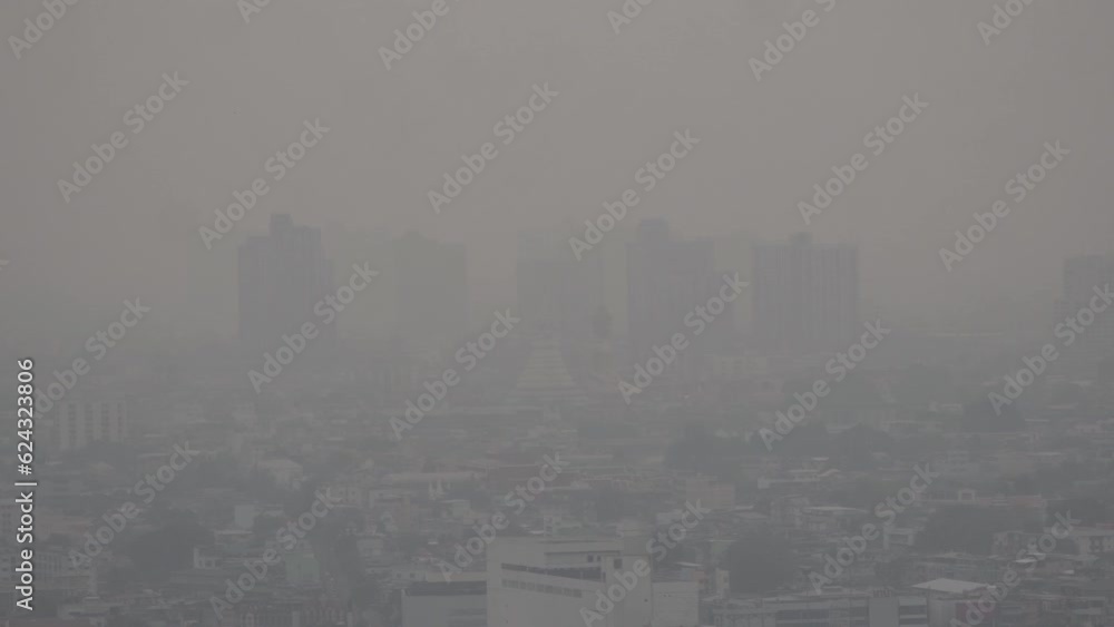 The cityscape of Bangkok is obscured by a thick blanket of dust and
