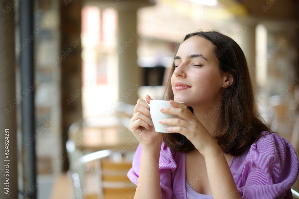 Woman relaxing smelling coffee aroma in a bar Woman relaxing smelling coffee aroma in a bar