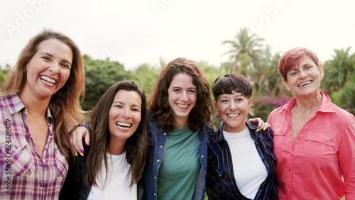 Multi-generational group of women hugging each outside park city - Multiracial people celebrate together