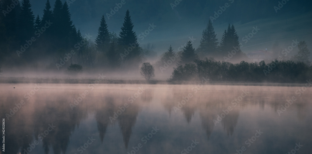 Fototapeta premium lever de soleil et brume matinale sur le lac de Lamoura dans le Haut Jura en France