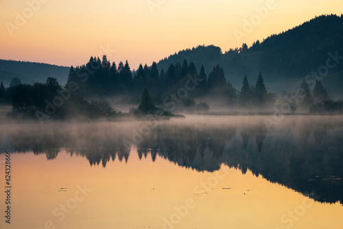 lever de soleil et brume matinale sur le lac de Lamoura dans le Haut Jura en France