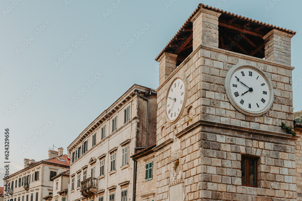 The clock tower on the army square at the entrance gate in the medieval city of Kotor. Evening view. Kotor, Montenegro The clock tower on the army square at the entrance gate in the medieval city of Kotor. Evening view. Kotor, Montenegro