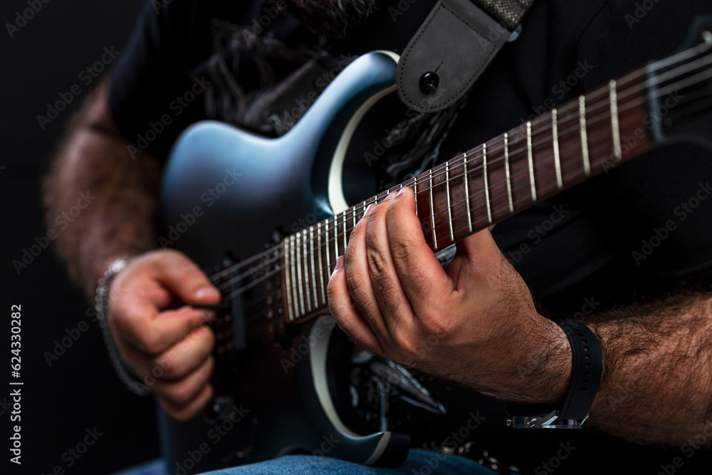 Obraz premium Brutal man's hands of the musician play the electric guitar. Hobby, passion and creativity. Close-up.