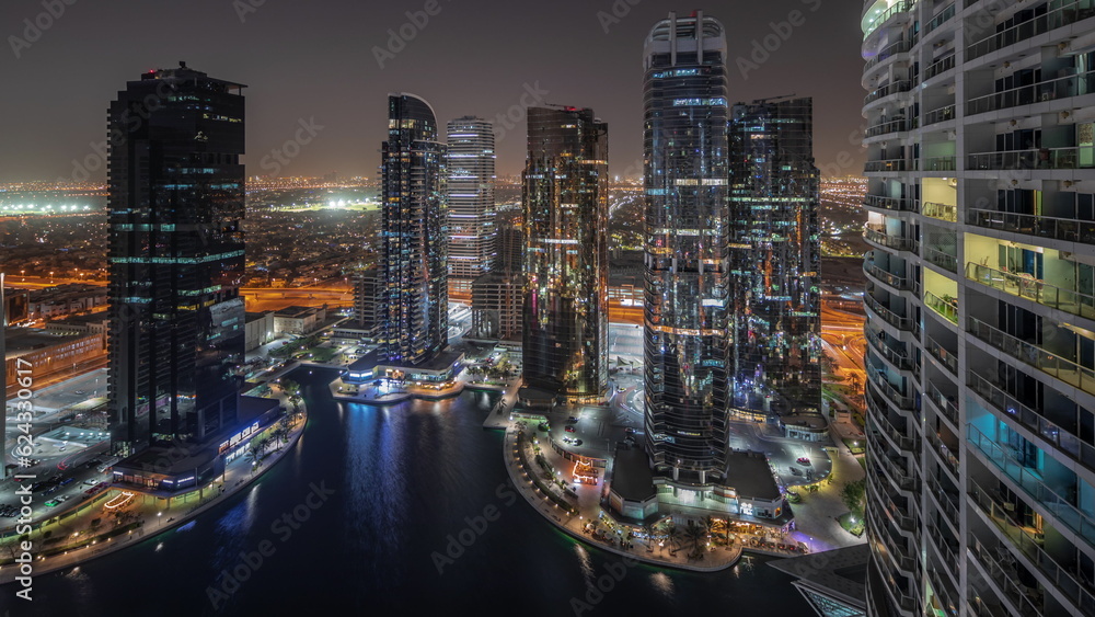 Tall residential buildings at JLT aerial night timelapse, part of the Dubai multi commodities centre mixed-use district.