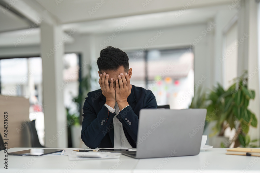 Overwork and deadline concept. Stressed asian businessman working on laptop, touching and massaging temples. Mature male having headache, reducing stress Overwork and deadline concept. Stressed asian businessman working on laptop, touching and massaging temples. Mature male having headache, reducing stress