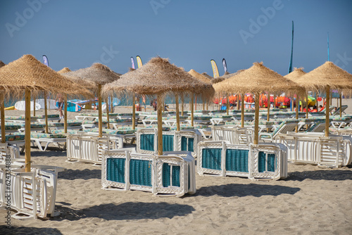 Sombrillas y hamacas en la playa de Carvajal, Benalmádena Costa, provincia de Málaga, España.