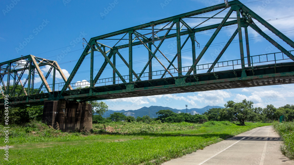 真夏の暑い日に遠賀川の河原で、福智山を鉄橋の下に眺める。On a hot midsummer day, on the banks of the Onga River, you can see Mt. Fukuchi under the iron bridge.