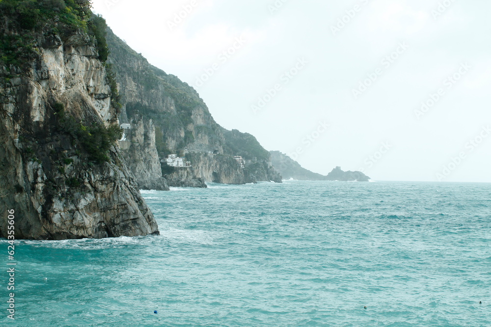 Dramatic cliff over the clear blue sea in Amalfi coast, Italy