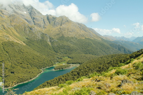 The bright blue water of Mckenzie Lake in the heart of Routeburn track in fiordland New Zealand, hidden in the valley between majestic mountains