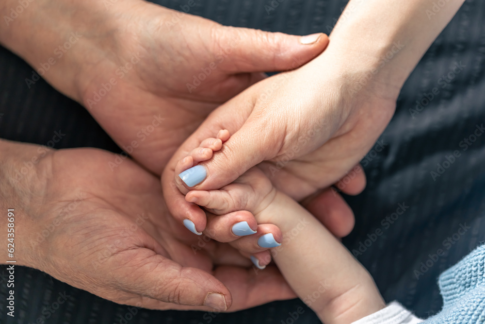 Close-up, hands of a baby, mother and grandmother. Close-up, hands of a baby, mother and grandmother.