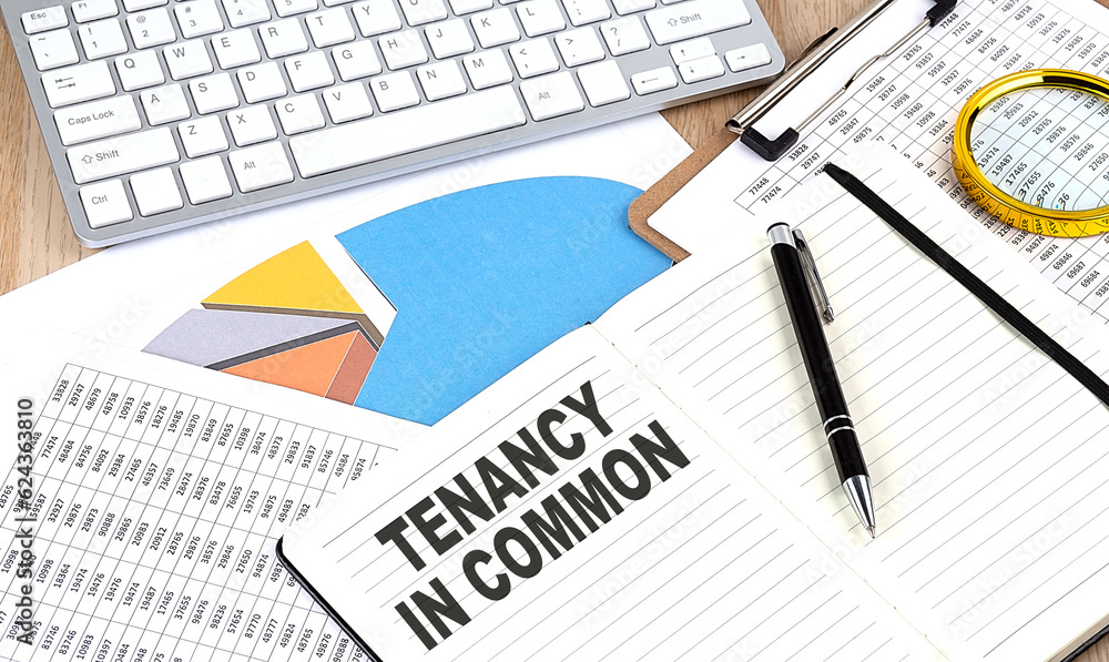 TENANCY IN COMMON text on notebook with chart and keyboard TENANCY IN COMMON text on notebook with chart and keyboard