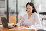 Young asian woman using laptop computer for business studying, watch online virtual webinar training meeting, video call. Focused asian woman or Latin business woman work in office, copy space. 
