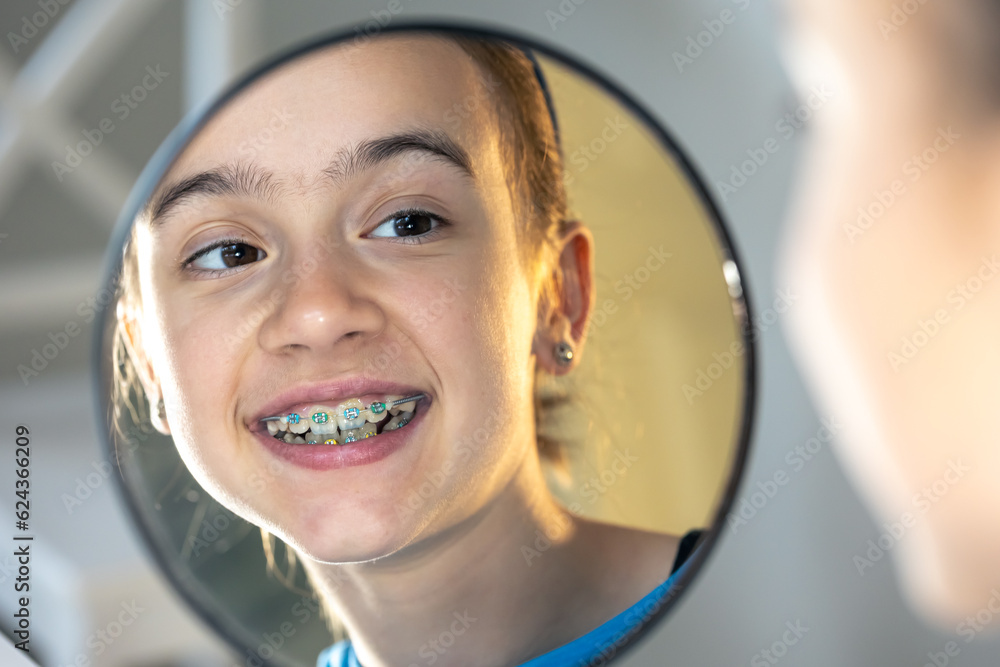 Poster Caucasian preteen girl with braces on her teeth looking at the