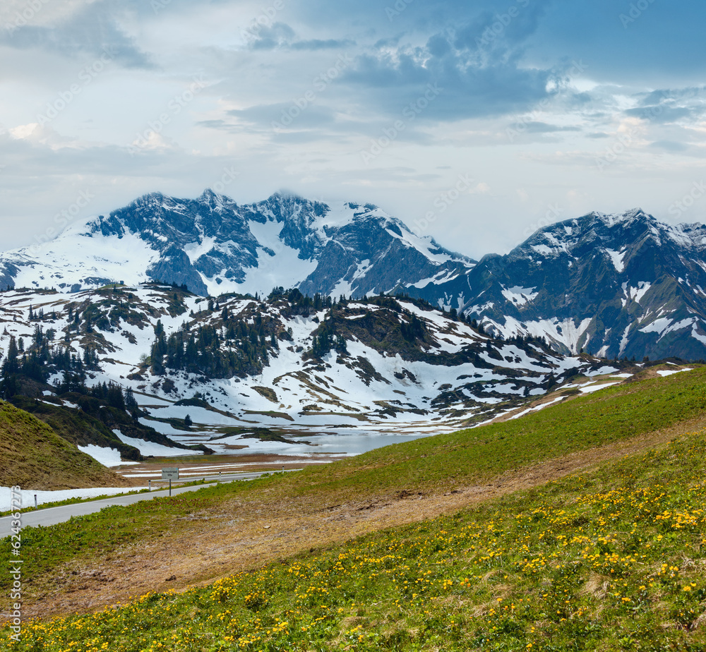 Summer mountain view to small Kalbelesee lake and snow thawing meadow (Warth, Vorarlberg, Austria).