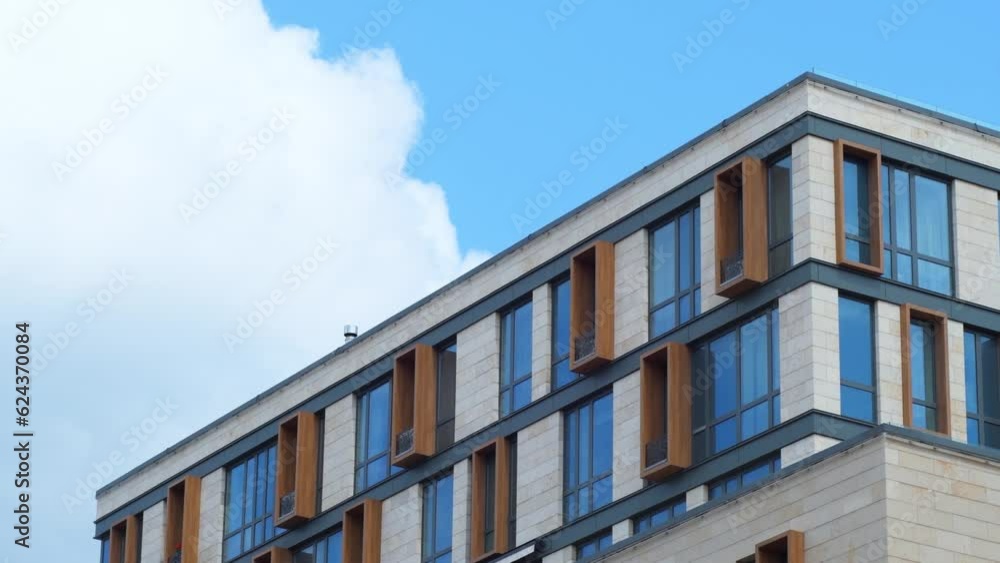 The upper part of a residential building against the background of the sky with clouds.