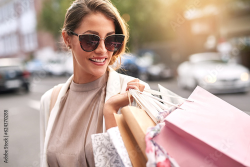 Fashion, shopping bag or rich girl in city or urban street for boutique retail sale or clothes discount deals. Sunglasses, financial freedom or trendy customer walking on road with luxury products